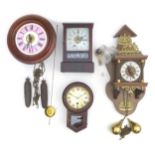 A group of four clocks, including a miniature drop dial wall clock, a small mantle clock, a pink