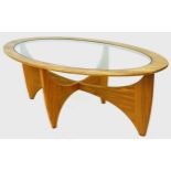 An oval form G-Plan coffee table, with glass top inset to a teak frame with shaped legs, 122.5 by 66