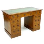 A mahogany twin pedestal desk, circa 1900, with nine drawers, turned handles, and green tooled