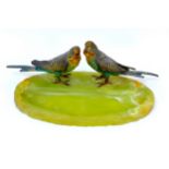 A green onyx pen stand topped with two cold painted bronze budgerigars, of oval form, 29 by 15 by