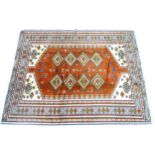 A Turkman rug, cream ground with central orange panel with eight cream diamonds of geometric design,