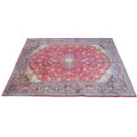 A large Araak rug, with red ground, central dark blue and cream floral medallion, central field