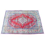 A Mahal rug, red ground with pale blue corners, central floral motif with multiple cream, floral