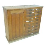 A 20th century oak multi-drawer cabinet, with nine short over four long drawers to its right side