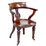 A Victorian mahogany desk armchair, shaped open arms, with pierced splat, saddle seat, raised on