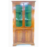 An Italian 19th century corner cabinet, cornice over twin glazed doors enclosing two fixed