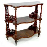 A set of Victorian walnut shelves, with three tiers, each of serpentine shaped outline with