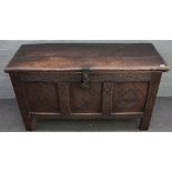 A late 17th century carved oak coffer, of panelled construction, with hinged top,