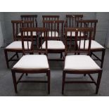 A set of eight George III mahogany stick back dining chairs on tapering square supports,