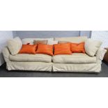A large modern square back sofa with cream loose covers, 255cm wide x 65cm high.
