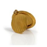 A gold circular pendant powder compact,