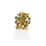 A gold and emerald ring, in an abstract design, claw set with twelve small circular cut emeralds,