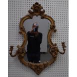 A Victorian cartouche shaped twin branch girandole wall mirror with opposing 'C' scroll crest,