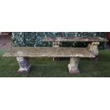 A reconstituted stone rectangular garden bench on scroll trestle end standards,