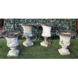 A pair of reconstituted stone jardinieres with flared rims and turned socles,
