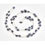 A silver and sapphire long chain, the oval link chain spectacle set with variously cut sapphires,