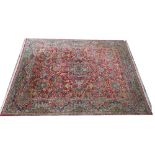 A Kerman carpet, Persian, the madder field with a central medallion, vase spandrels,