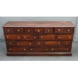 A 20th century hardwood low apothecary chest with nineteen various drawers on plinth base,