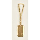 A gold key ring with a curved rectangular initial engraved panel and with a screw top fitting,