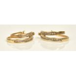 A pair of 9ct gold and diamond earrings, each in a graduated twin hoop shaped design,