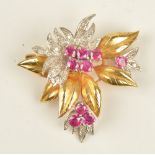 An 18ct two colour gold, ruby and diamond brooch, designed as a floral and foliate spray,