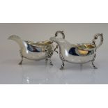 A pair of silver sauceboats, each having a shaped rim,
