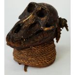 An African tribal rattle, mounted with a monkey's skull, 19cm high.
