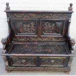 A late 19th century carved oak box seat settle, with recumbent beast arm supports,