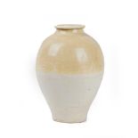 A Chinese Liao style pottery vase, of ovoid form, the top half covered in a deep cream glaze,