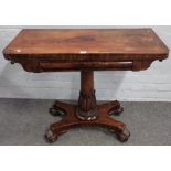 A Regency mahogany card table on carved and turned column and four scroll feet,
