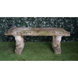A reconstituted stone garden bench on serpent trestle supports, 130cm wide,