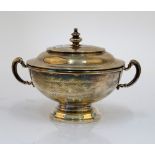 A silver twin handled bowl and cover, of circular form, raised on a circular foot,