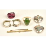 A gold ring, claw set with an oval cabochon nephrite, between decorated shoulders, ring size P,