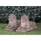 A pair of reconstituted stone figures of recumbent lions on rectangular bases,