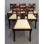 A set of six George III mahogany dining chairs, with carved waist rails on sabre supports,