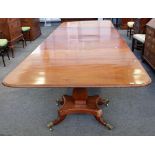 A William IV mahogany triple pedestal extending dining table on three square baluster columns and