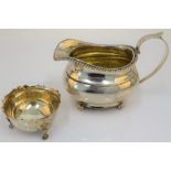 A George IV silver milk jug, of compressed helmet shaped form, decorated with a gadrooned rim,