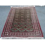 A Turkman rug, the washed sage field with three columns of nine guls; an ivory border,