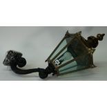A Victorian hexagonal brass lantern, with glazed sides, supported on a scrolling wall bracket,