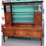 An 18th century mahogany banded oak dresser, the open three tier plate rack, with pair of cupboards,