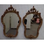 A pair of Victorian gilt framed shaped wall mirrors with scrolling crests and leaf chased frames,