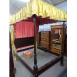 A mahogany four poster bed, the pleated canopy over reeded footend columns,