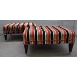 A pair of modern rectangular foot stools with striped upholstery on tapering ebonised supports,