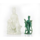 A Chinese moulded glass figure of Guanyin, of pale green tone, the goddess seated on a rocky base,