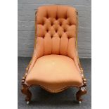 A Victorian walnut slipper back nursing chair, with serpentine seat on scroll supports,