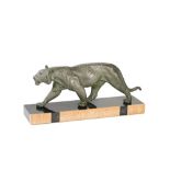 An Art Deco patinated spelter sculpture of a lioness, mounted on a rectangular marble base,