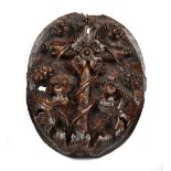 A 17th century Italian walnut oval panel relief carved with a fruiting vine,