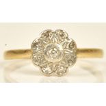 A gold and diamond set cluster ring, mounted with a circular cut diamond at the centre,