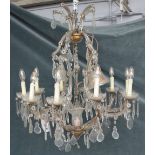 A 20th century glass ten-light chandelier, with scrolling branches and hung with faceted drops,