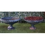 A pair of late 19th century green painted cast iron shallow jardinieres with fluted bodies and